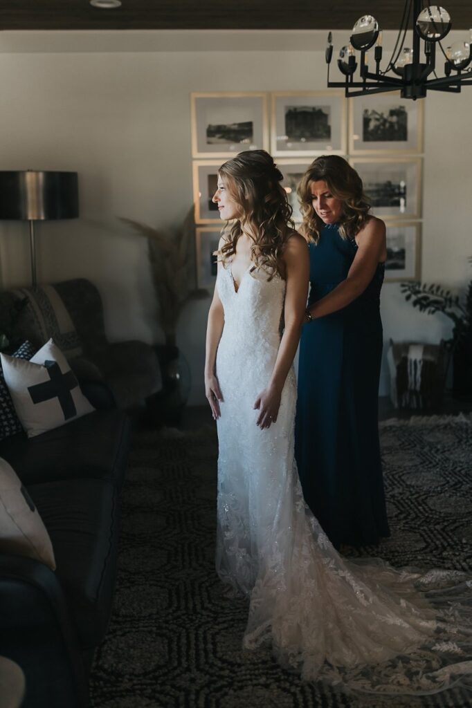 Bride and mom getting wedding dress on in Bethel Rock bridal house